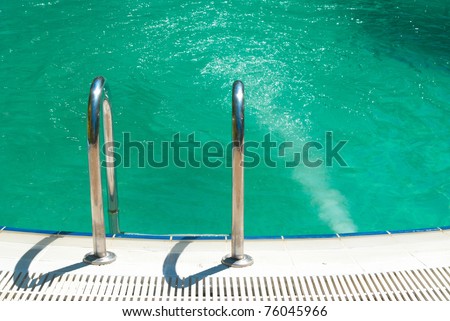 Swimming pool with stair and green relaxing water
