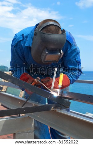 Welder at the factory working with metal construction