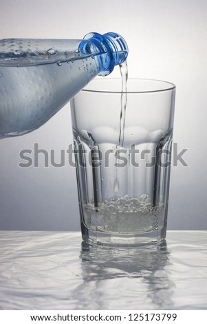 Pouring sparkling water into a caipirinha glass