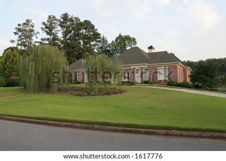 ranch house with trees in the front yard