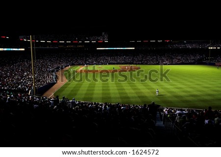 high contrast image of Turner Field at night; the stadium is highlighted in green, with crowd very dark