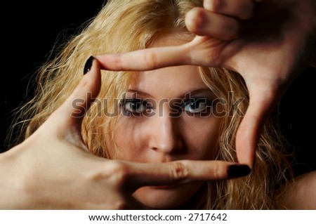Face of beauty girl framed her hands over black background