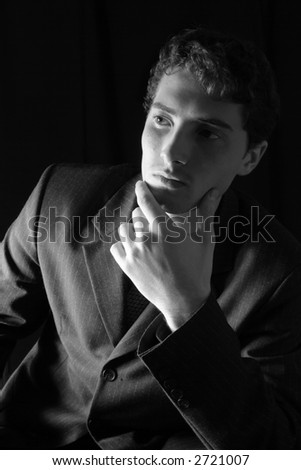 Pensive office worker over black background. Black&white.
