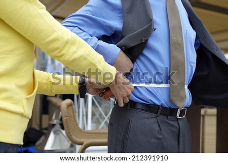 Personal trainer measuring a businessman waist at the gym