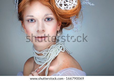 Redheaded girl with new-year decorations in a hair-do. Beautiful New Year and Christmas Tree Holiday Hairstyle and Make up.