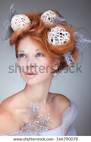 Redheaded girl with new-year decorations in a hair-do. Beautiful New Year and Christmas Tree Holiday Hairstyle and Make up.