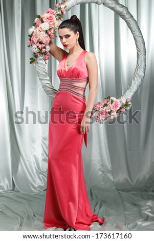 Beautiful sexual brunette in n evening dress with the hoop with pink flowers