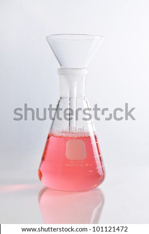 Erlenmeyer flask and Glass funnel on white blackground isolation for use in chemcial science laboratory. Red soltion inside it.