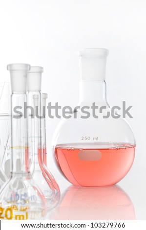 Round-bottom flask on white blackground isolation for use in chemcial science laboratory. Red soltion inside it.