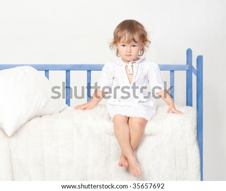 little girl sitting on the bed