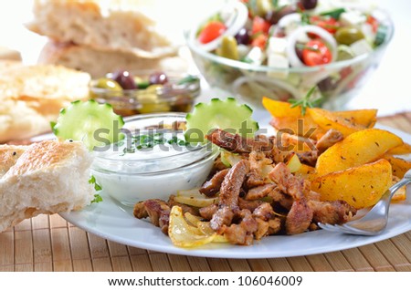 Greek gyros with fried potatoes and tzatziki, served with pitabread an Greek salad