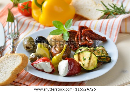 Delicious mediterranean antipasti (stuffed peppers, stuffed mushrooms, grilled zucchini, stuffed green olives, black olives, fried and pickled champignons, sun-dried tomatoes)