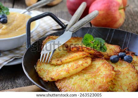 Crispy fried homemade potato pancakes served in an iron pan with apple sauce