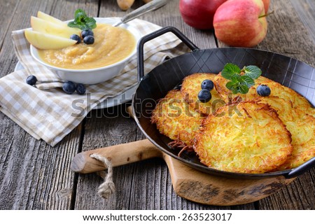 Crispy fried homemade potato pancakes served in an iron pan with apple sauce