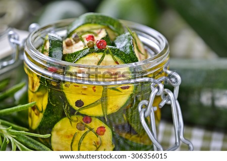 Fried zucchini slices pickled in olive oil with herbs and filled in a canning jar