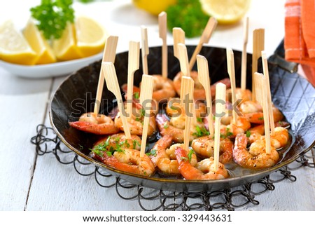 Spanish tapas - fried spicy prawns with olive oil, Sherry and garlic, served in an iron frying pan