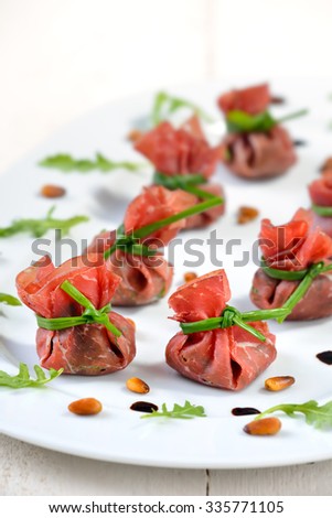 Delicious air-dried beef ham - Italian Bresaola -  stuffed with chopped rocked salad, roasted pine nuts, parmesan cheese and creamy balsamic vinegar, tied up with blanched chives