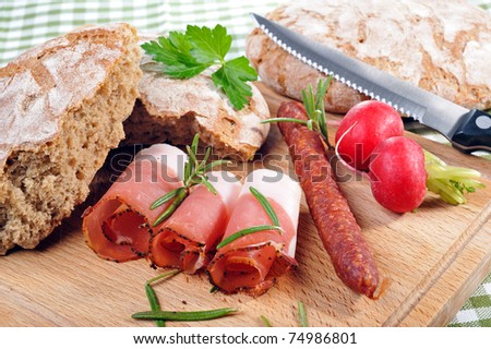 Snack with bacon and sausage on a wooden plate
