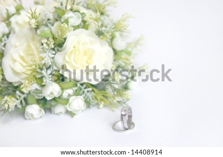 stock photo Wedding rings and floral bouquet in highkey still life