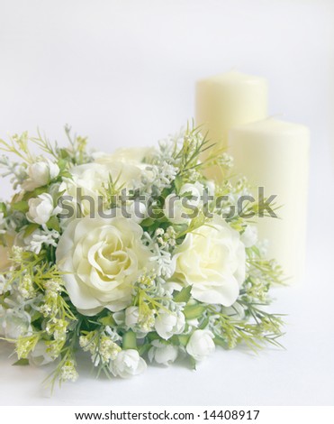 Wedding decoration with bridal bouquet or floral centerpiece and cream church candles