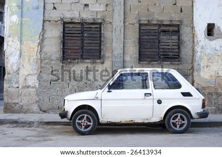 This image shows an old car against the crumbling buildings of Havana, Cuba