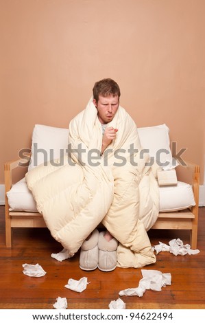 A sick man on the couch coughing
