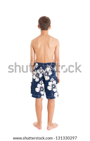 Portrait of a boy wearing swimming shorts. A boy stands with his back to the camera. Studio shot, isolated on white background.
