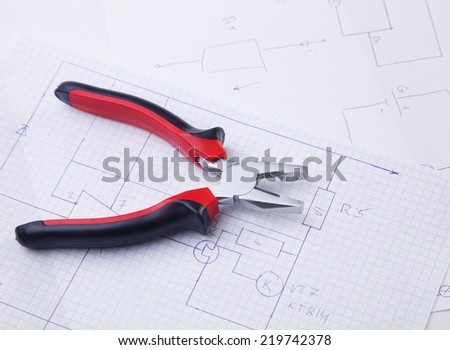Pliers on the background of the electric scheme