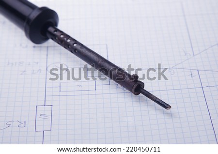 Soldering iron  on a background of the electric scheme