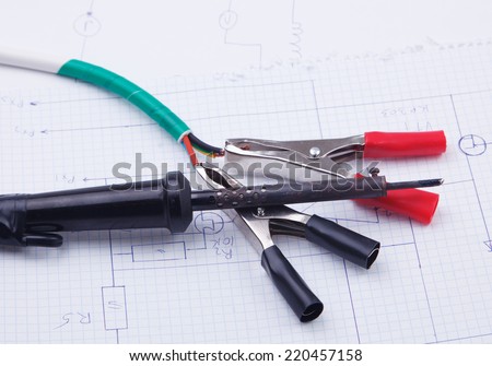 Electric clamps and a soldering iron on a background of the electric scheme