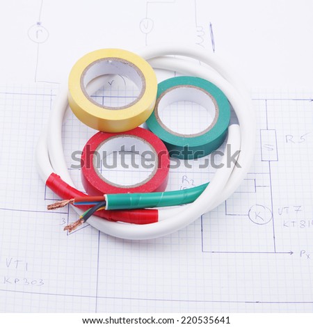 Adhesive plastic tape and electric cable on a background of the electric scheme