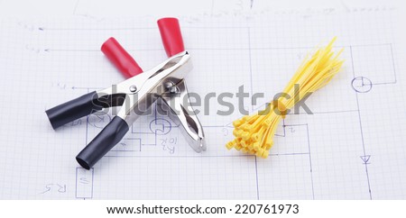 Electric clamps and plastic ties on electric scheme background