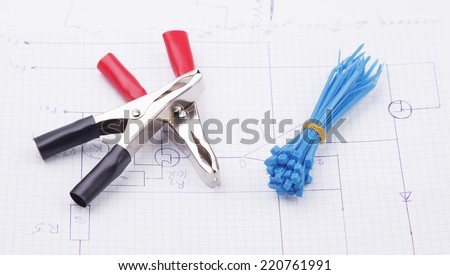 Electric clamps and plastic ties on electric scheme background