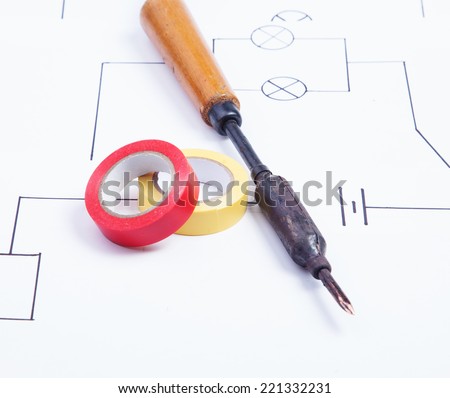 Soldering iron on a background of the electric scheme