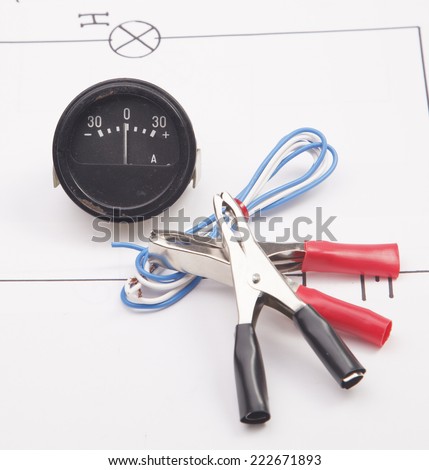 Ammeter and electric clamps on a background of the electric scheme