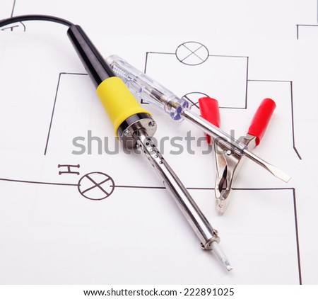 Soldering iron and electric clamps and  on a background of the electric scheme