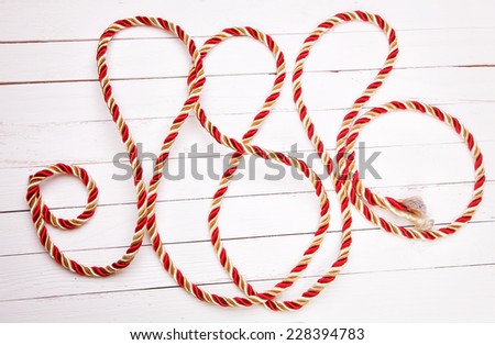 Red rope on a white background wooden table