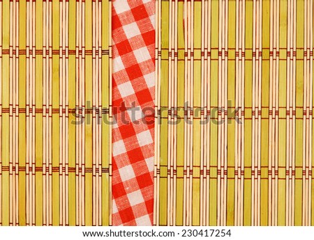 Color bamboo mat and tablecloth red and white checkered wavy on wooden table