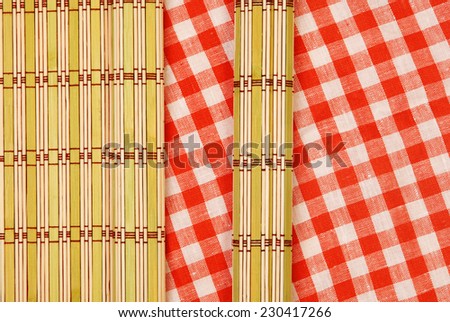 Color bamboo mat and tablecloth red and white checkered wavy on wooden table