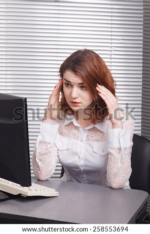 Tired business woman looks tired in the computer
