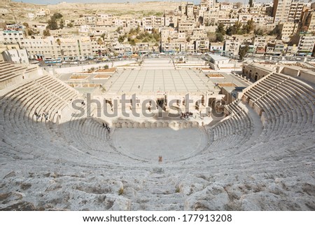 AMMAN, JORDAN - FEBRUARY 3: Ancient roman theater and city view with people in Amman, Jordan, Middle East, on February 3rd, 2014. Amman the capital of Jordan spreads on seven hills.