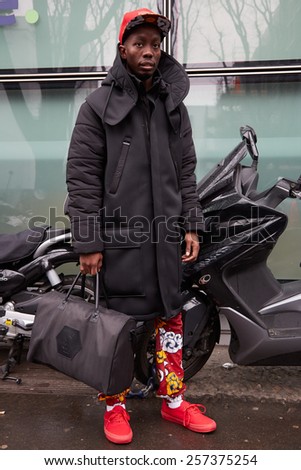 MILAN - MARCH 2: Man poses for photographers before Giorgio Armani show with Yves Saint Laurent bag, Milan Fashion Week Day 6, Fall/Winter 2015/2016 street style on March 2, 2015 in Milan.