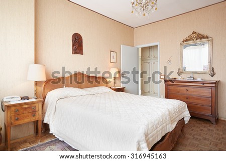 Old bedroom with queen size bed in ancient italian house