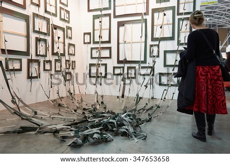 TURIN, ITALY - NOVEMBER 6: Artissima, contemporary art fair opening with people, galleries and art collectors on November 6, 2015 in Turin, Italy. Woman looking at art installation with frames.
