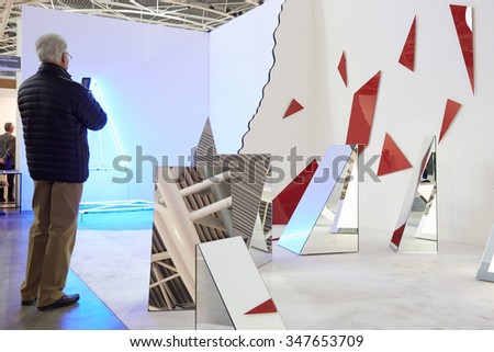 TURIN, ITALY - NOVEMBER 6: Artissima, contemporary art fair opening with people, galleries and art collectors on November 6, 2015 in Turin, Italy. Man photographing with smartphone mirror art installation.