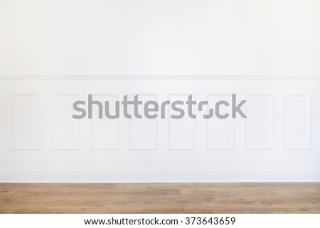 Empty white room with parquet floor and wood trimmed wall