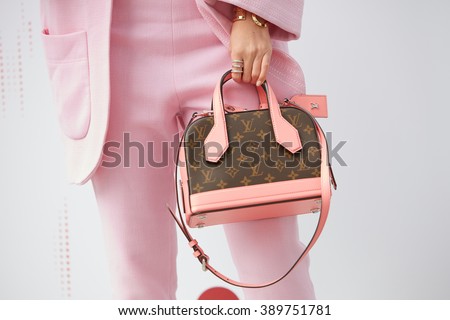 MILAN - FEBRUARY 25: Woman poses with pink and brown Louis Vuitton bag and pink suit before Costume National fashion show, Milan Fashion Week Day 2 street style on February 25, 2016 in Milan.