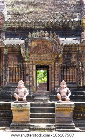 Frontal shot of statue guardian in front of a building at Temple Banteay Srei in Angkor