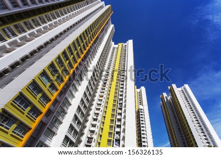 A low angle shot of a new colorful high rise apartment against the sky.