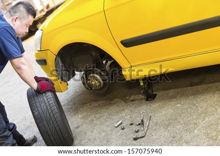 A mechanic looking troubled is preparing to change tire